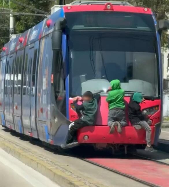 Tehlikeli yolculuk! Bursa'da tramvayın arkasına tutunarak ilerleyen 3 çocuk, tehlikeli yolculuklarıyla yürekleri